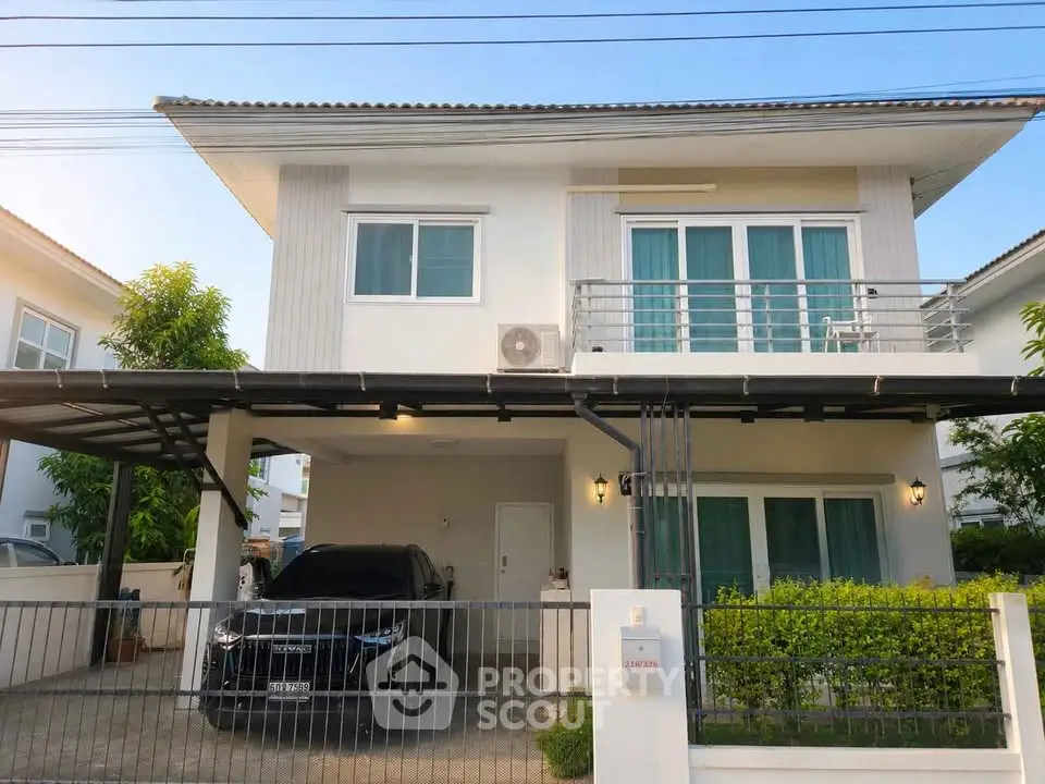 Modern two-story house with carport and balcony in a suburban neighborhood.