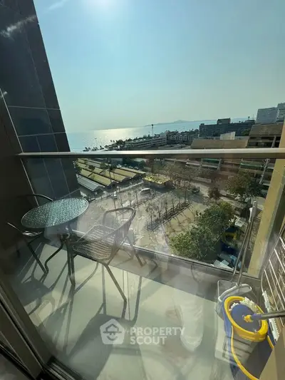 Stunning balcony view overlooking the ocean with modern outdoor seating, perfect for relaxation.