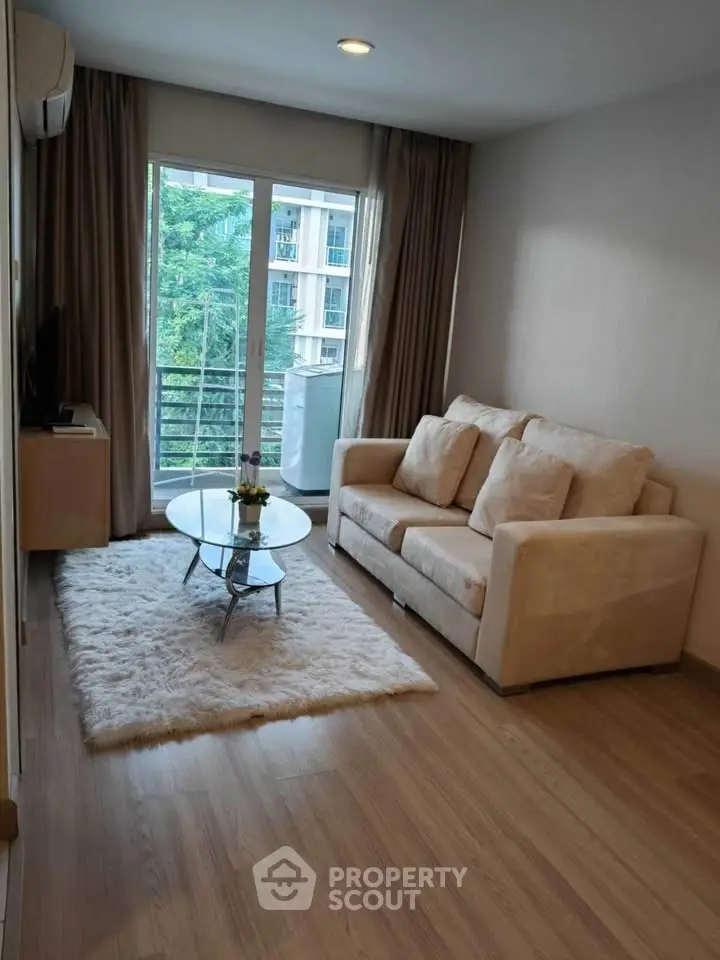 Cozy living room with plush sofa and large window offering a serene view.