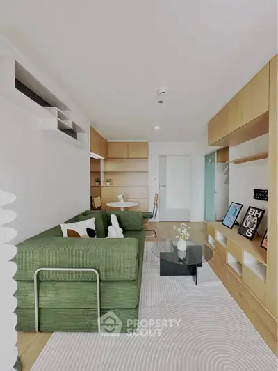 Modern living room with green sofa, stylish decor, and open layout in contemporary apartment.