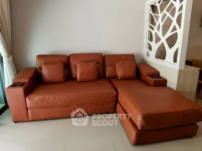 Modern living room with stylish brown leather sectional sofa and elegant decor.