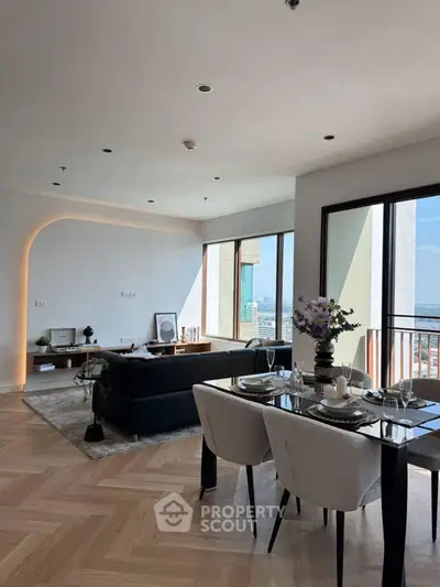 Elegant open-plan living and dining area with city view and modern decor.