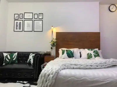 Stylish bedroom with cozy bed, chic sofa, and modern decor accents.