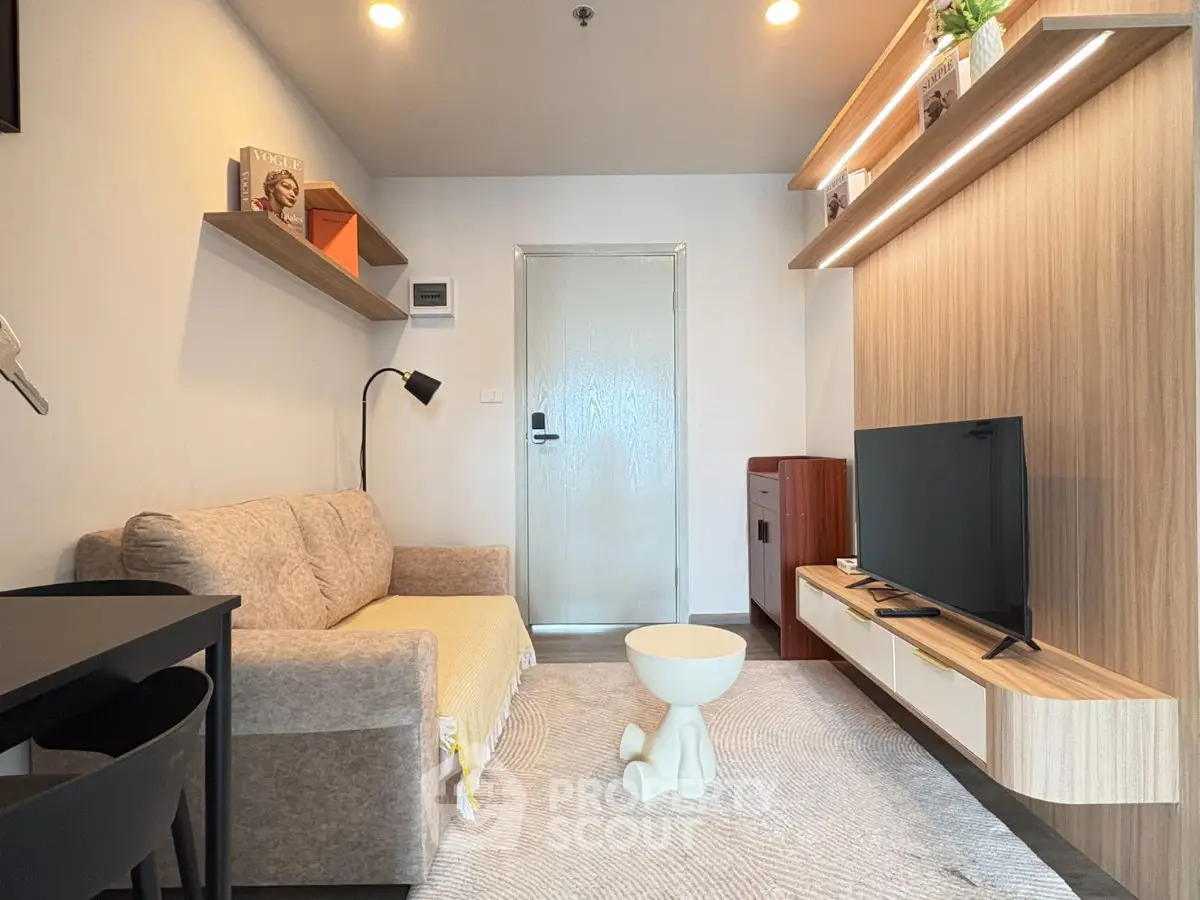 Modern living room with stylish furniture and wall-mounted TV in a cozy apartment.