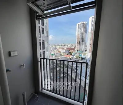 Stunning city view from high-rise balcony with modern railing and open sky.