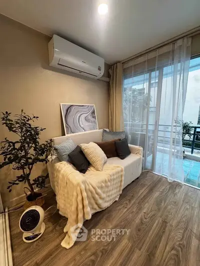 Chic living room with cozy sofa, modern decor, and balcony view in stylish apartment.