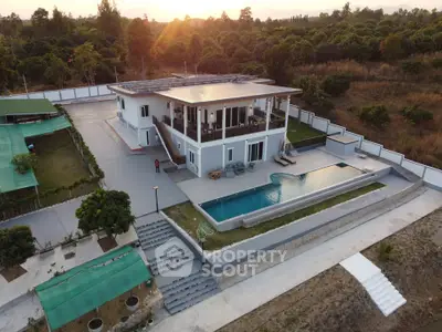 Stunning modern villa with infinity pool and lush surroundings at sunset.