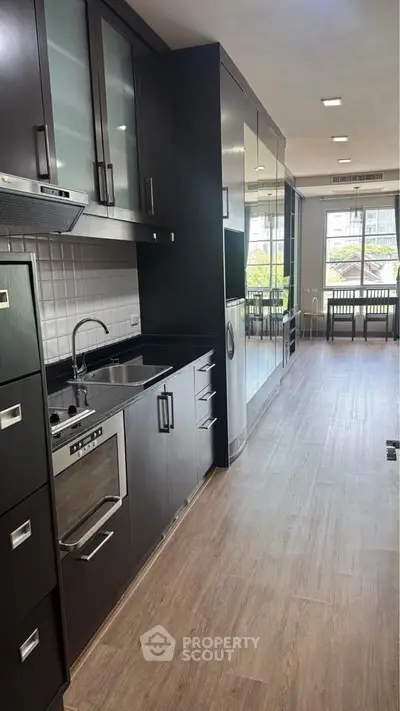 Modern kitchen with sleek black cabinetry and built-in appliances in a stylish apartment.