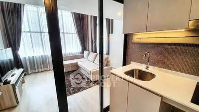Modern open-layout living room with sleek kitchen and large windows