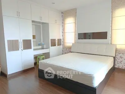 Spacious bedroom with modern design and ample storage in a stylish apartment.