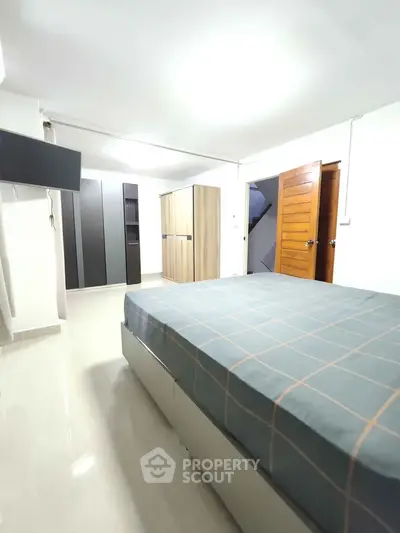 Spacious bedroom with modern furniture and ample storage space