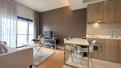 Modern open-layout living room and kitchen with stylish decor and natural light.