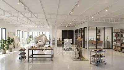 Spacious art studio with modern design and natural light, featuring sculptures and workstations.