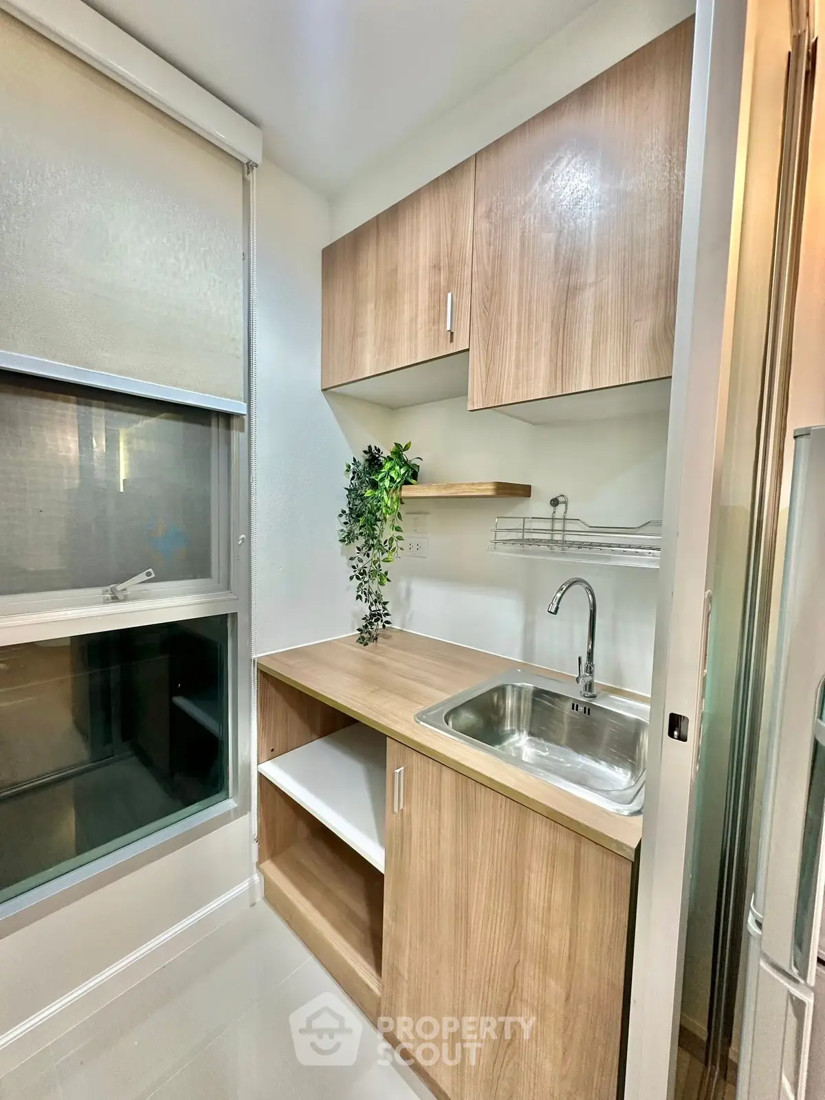 Modern kitchen with sleek wooden cabinets and stainless steel sink, perfect for urban living.