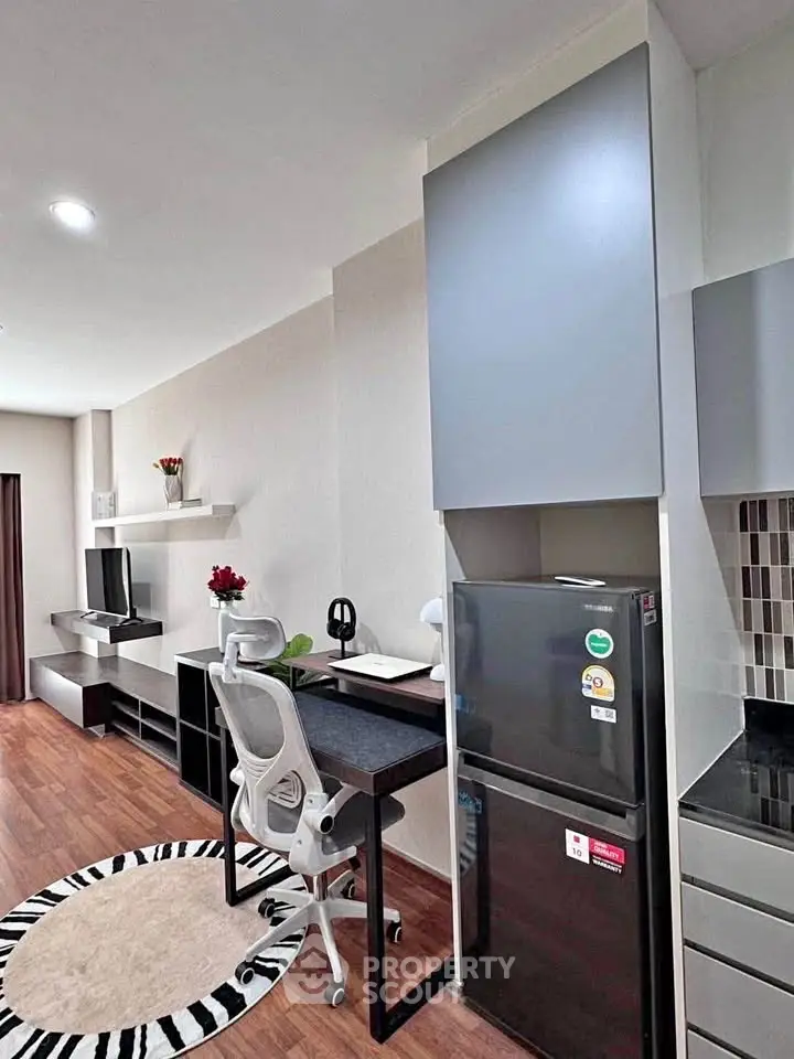 Modern studio apartment with sleek furniture and compact kitchen area, ideal for urban living.