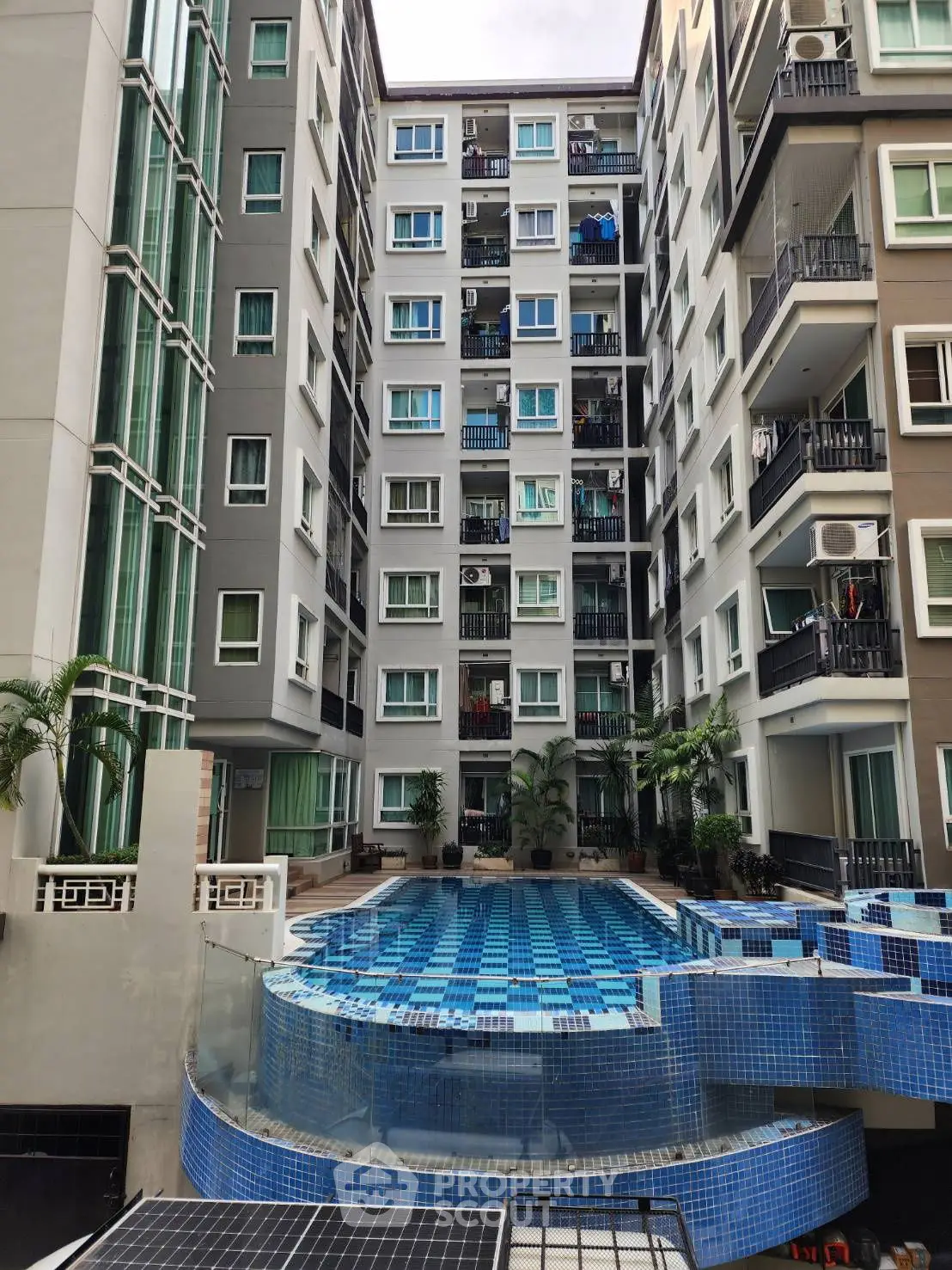 Modern apartment building with a stylish pool and balconies, perfect for urban living.