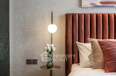 Elegant bedroom with plush headboard and modern bedside lamp