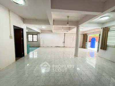 Spacious open-plan living area with tiled flooring and ample natural light