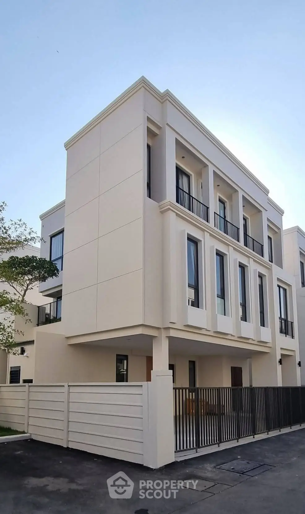 Modern three-story townhouse with sleek design and spacious balconies in a serene neighborhood.