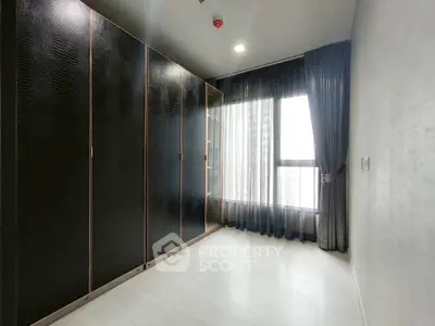 Spacious bedroom with large wardrobe and floor-to-ceiling window