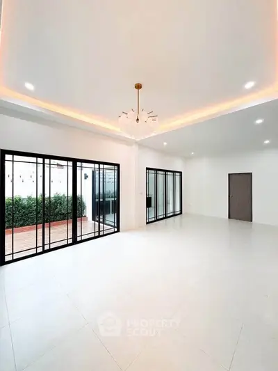 Spacious modern living room with large windows and garden view, perfect for family gatherings.