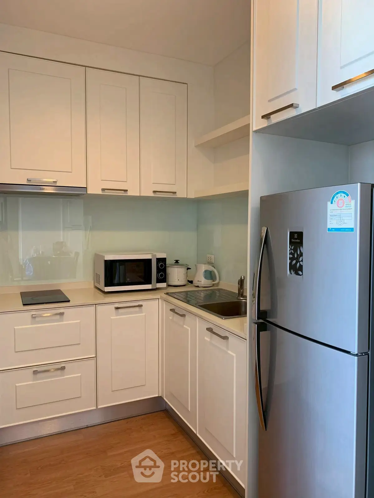 Modern kitchen with sleek white cabinets and stainless steel appliances.