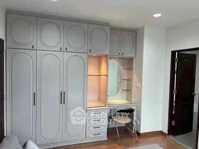 Elegant bedroom with built-in wardrobe and vanity in modern design.