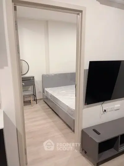 Modern bedroom with sleek furniture and wall-mounted TV