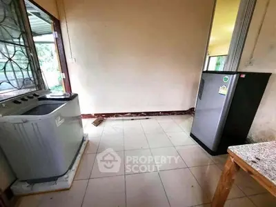 Compact laundry room with washing machine and refrigerator, tiled floor, and open window view.