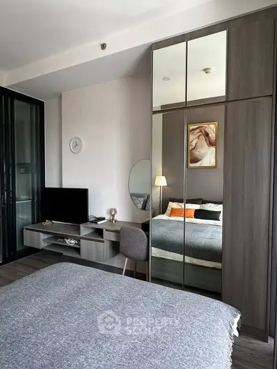 Modern bedroom with stylish decor, mirrored wardrobe, and cozy ambiance in a contemporary apartment.