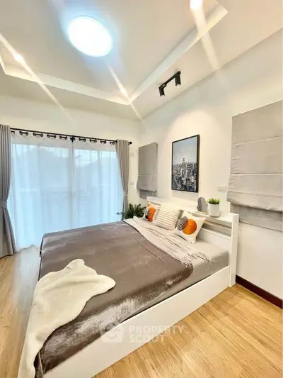 Spacious modern bedroom with elegant decor and large windows for natural light.