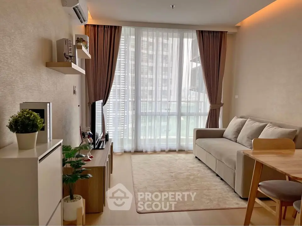 Modern living room with cozy sofa, large window, and stylish decor in a high-rise apartment.
