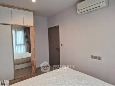 Modern bedroom with built-in wardrobe and air conditioning unit