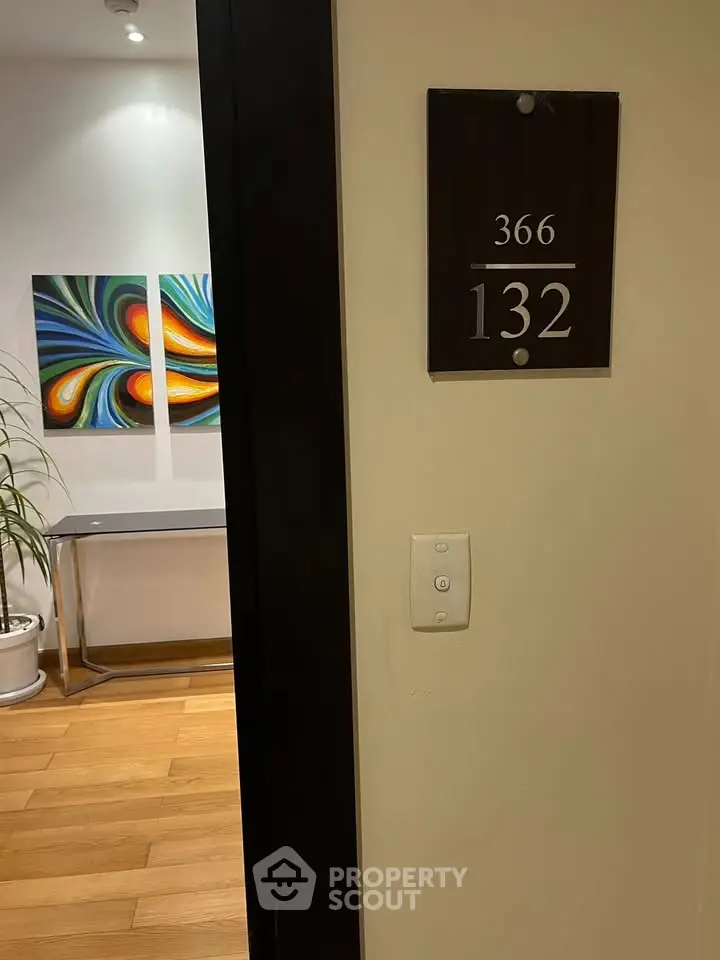 Stylish apartment entrance with modern art and wooden flooring