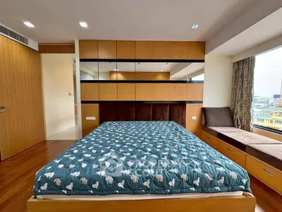 Spacious bedroom with modern design and large windows offering city views.