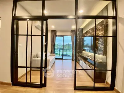 Modern living room with glass doors and scenic view, featuring elegant decor and spacious layout.