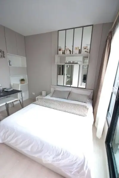 Modern bedroom with stylish decor and large window offering natural light