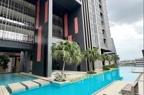 Luxurious modern building with stunning pool and palm trees, offering a serene urban oasis.