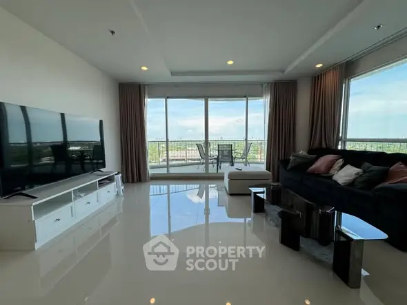 Spacious living room with large windows and balcony offering stunning views.