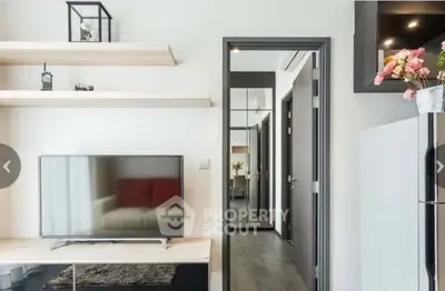 Modern living room with sleek TV setup and stylish shelving in a contemporary apartment.