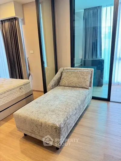 Modern bedroom with stylish chaise lounge and floor-to-ceiling windows