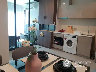 Modern kitchen with open layout, sleek cabinetry, and integrated appliances, adjacent to a cozy dining area with natural light.