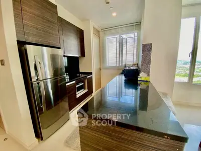 Modern kitchen with sleek dark wood cabinets and stainless steel appliances in a bright apartment.