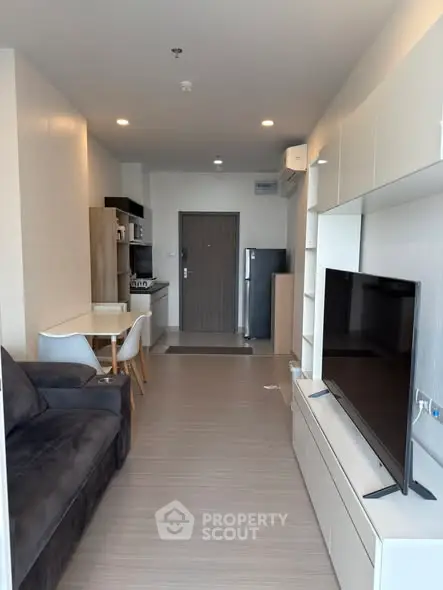 Modern living room with sleek furniture and open kitchen layout in a stylish apartment.