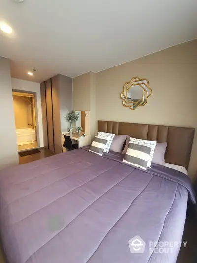 Elegant bedroom with plush bedding, modern decor, and an en-suite bathroom, showcasing a serene and luxurious living space.