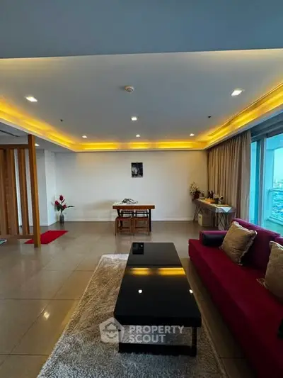 Spacious modern living room with elegant lighting and large windows offering a stunning view.
