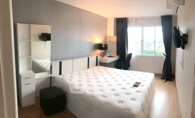 Modern bedroom with large window and stylish decor in a contemporary apartment.