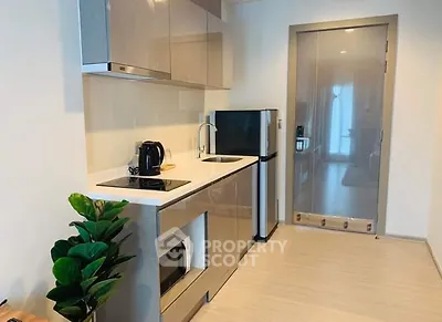 Modern kitchen with sleek cabinetry and compact appliances in a stylish apartment.