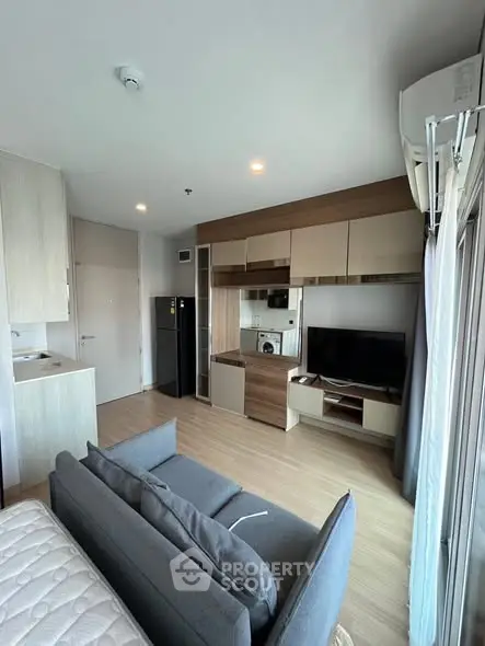 Modern living room with sleek furniture and integrated kitchen appliances