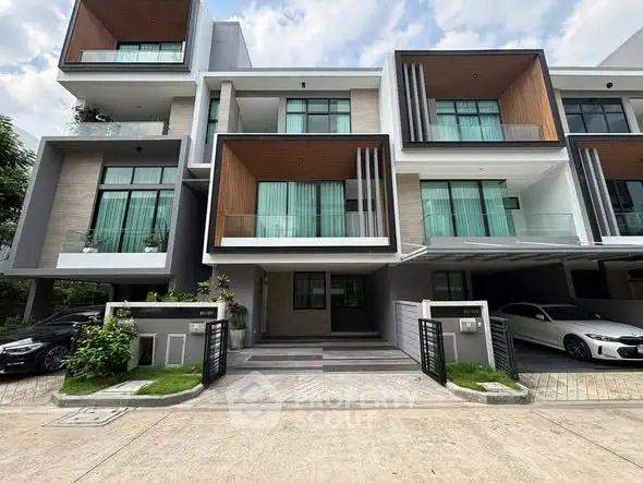 Modern multi-level townhouse with large windows and sleek design in urban setting.
